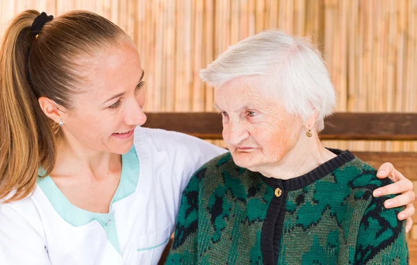 Mujer anciana con cuidador — Foto de Stock