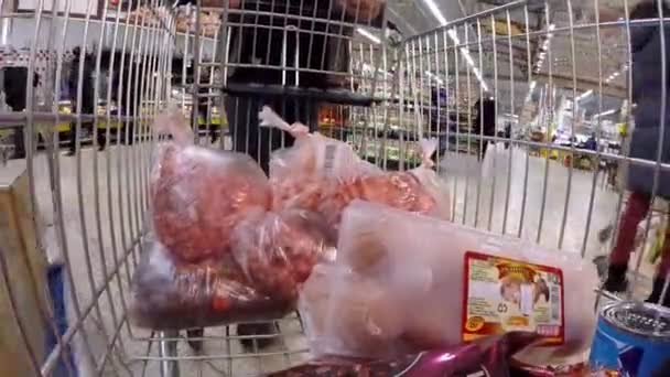 03/23/2016 року Мінськ, гіпермаркет "Euroopt": Купівля товарів у гіпермаркеті. М'ясо, яйця і покупка продуктів. Людина рулонах кошик з їжею — стокове відео