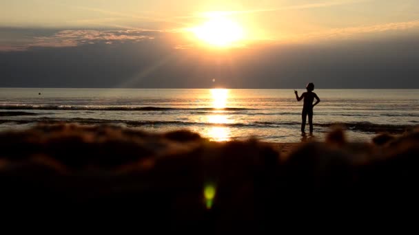 Kız sahilde oynarken. Günbatımı — Stok video