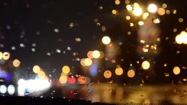 Ufuk ışık. Yağmurlu bir karayolu üzerinde fren arabalar. Camda yağmur.