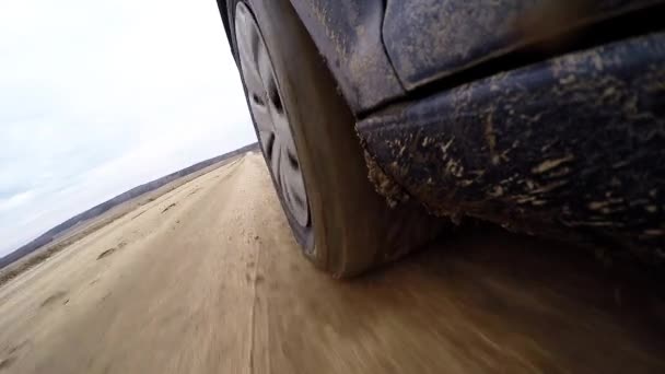 Ruedas de coche en el barro en el bosque, fuera de la carretera. Conduciendo por la carretera del campo. Vista desde la cabina del coche exterior. POV — Vídeo de stock