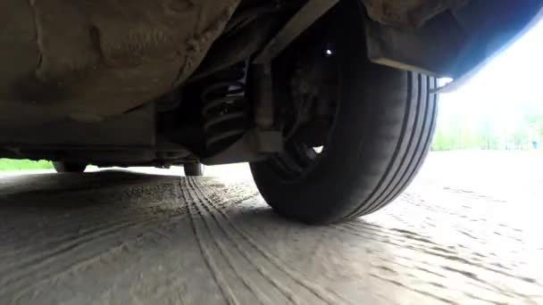 The camera from below the car. Work vehicle suspension. Driving on off road terrain — Stock video