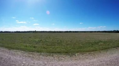 Arabanın tekerlekleri arasında video kamera. Kamera yolu üzerinden uçar. Kamera kenarda yüzer. Köy boyuna kaldırıma