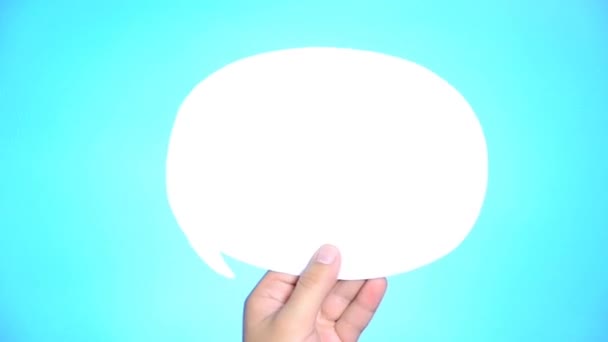 Hand holding an empty speech bubble on blue background. — Stock Video