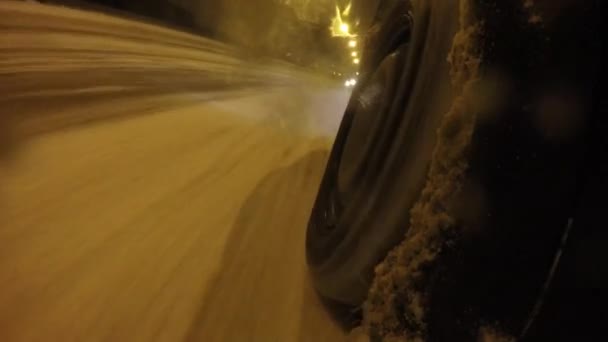 在积雪的路上的车轮特写。汽车乘坐雪覆盖城市的街道 — 图库视频影像