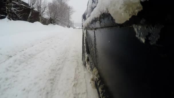 Wiel close-up op besneeuwde wegen. De auto rijdt op een besneeuwde straten van de stad — Stockvideo