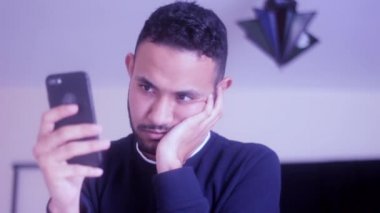 Sıkıcı adam cep telefonunu tutuyor ve kontrol ediyor.