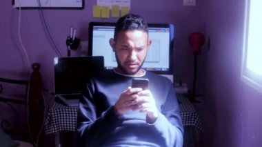  Telefona bakan genç bir adam kötü haberler görüyor.