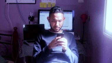 Mutlu Arap genç adam cep telefonunu kontrol ediyor.