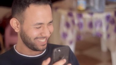 Kapalı çekim gülümsemesi evdeki cep telefonundan gelen bir mesajı okuyor.