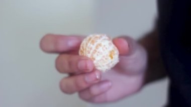 Adam elle kontrol ediyor ve mandalina tutuyor.