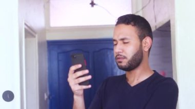 Genç adam evde iyi kötü mesaj ya da e-posta okuyor.