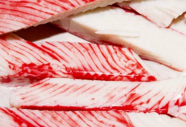 Yengeç çubuğu. Yengeç etinin arka planı. Beyaz balık etinden yapılmış yengeç çubukları..