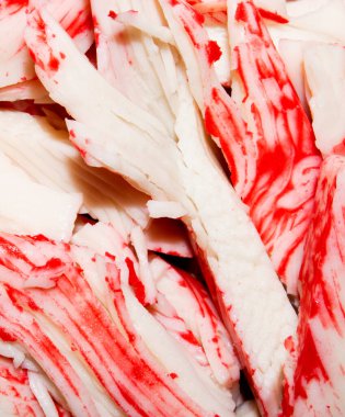 Yengeç çubuğu. Yengeç etinin arka planı. Beyaz balık etinden yapılmış yengeç çubukları..