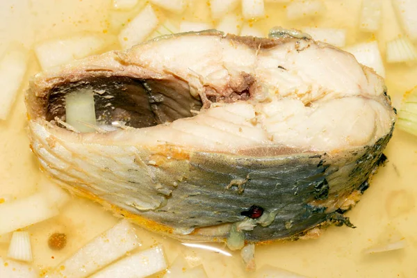 Herring boiled in fish broth with onions.Fish soup.A piece of fish in fish broth with onions.