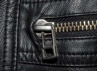 Siyah desenli metal fermuarlı deri. Siyah deri arka planda metal fermuar. Fermuarlı siyah deri ceketin yakın çekimi..