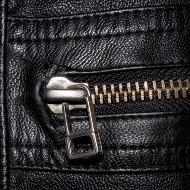 Siyah desenli metal fermuarlı deri. Siyah deri arka planda metal fermuar. Fermuarlı siyah deri ceketin yakın çekimi..