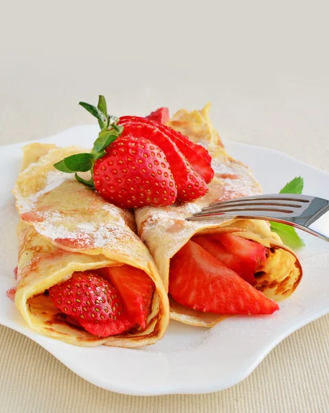 Crepes with strawberries sprinkled with powered sugar — Stock Photo, Image