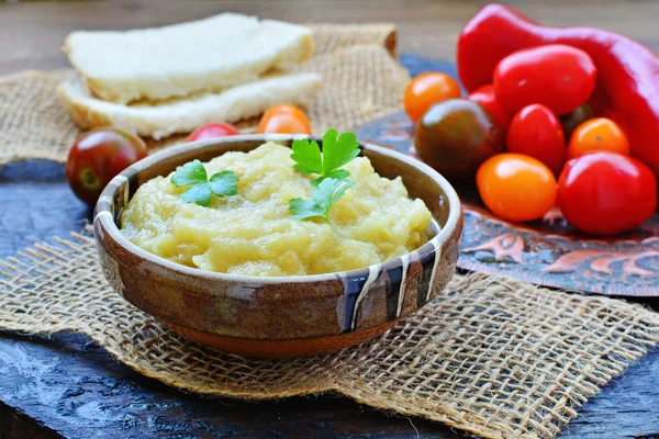 Eggplant dip in bowl with grape tomatoes in rustic table setting — Stock Photo, Image