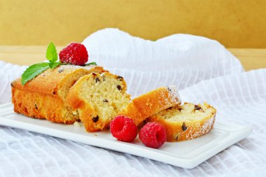 Çikolata ve beyaz tabakta ahududu ile pasta ekmek dilimlenmiş