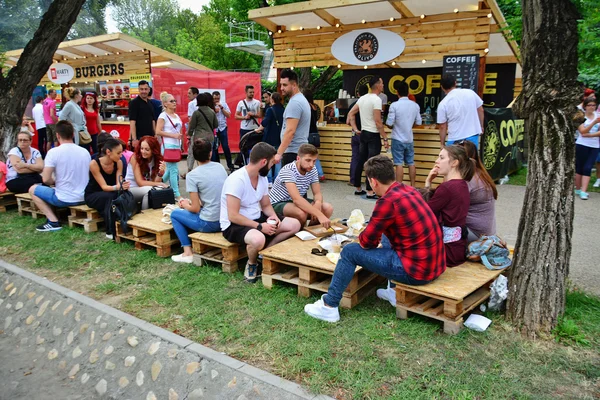 La gente toma un aperitivo en el Street Food Festival en el parque central Cluj . — Foto de Stock