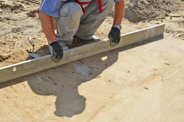 Worker screeding sand bed — Stock Photo, Image