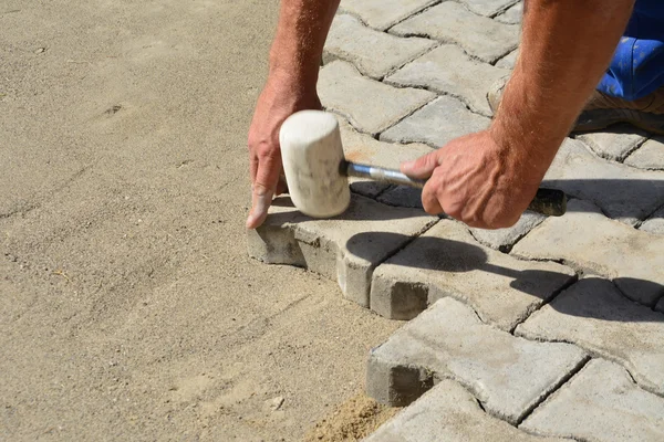 Travailleur pose verrouillage pavés en béton — Photo