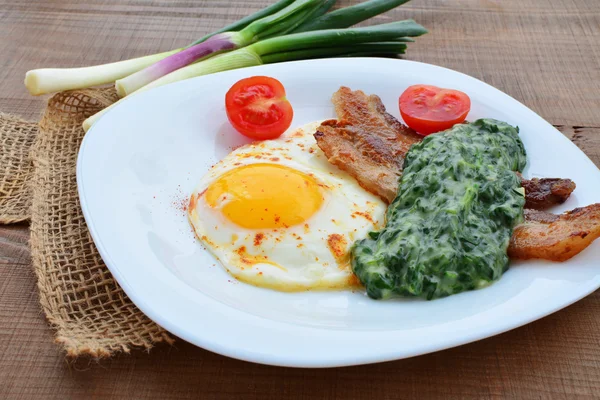 Ovo frito com espinafre cremoso e bacon — Fotografia de Stock