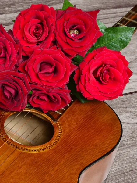 Ramo de rosas rojas encima de la guitarra acústica —  Fotos de Stock