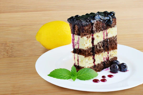 레몬 착 빙과 블루베리 소스와 함께 코코아 스폰지 케이크 — 스톡 사진
