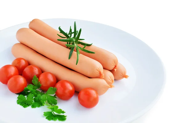 Saucisses et légumes sur plaque blanche isolée Images De Stock Libres De Droits