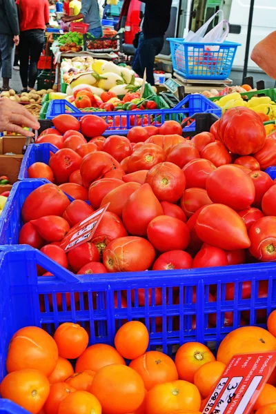 Tomates frescos rojos y naranjas en el mercado de los agricultores — Foto de Stock