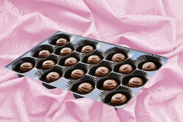 Choklad godis i brun låda över silk bakgrund — Stockfoto