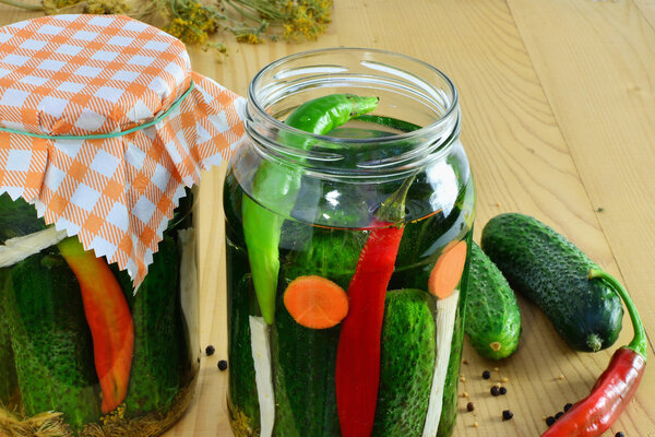 Pickles in jars and ingredients herbs and spices