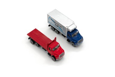 Beyaz arka planda izole edilmiş iki oyuncak kamyon..