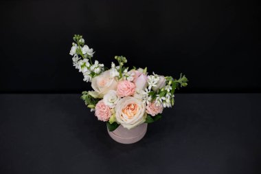 Çiçek aranjmanı narin şakayıklar ve diğer çiçekler, koyu bir arka planda..