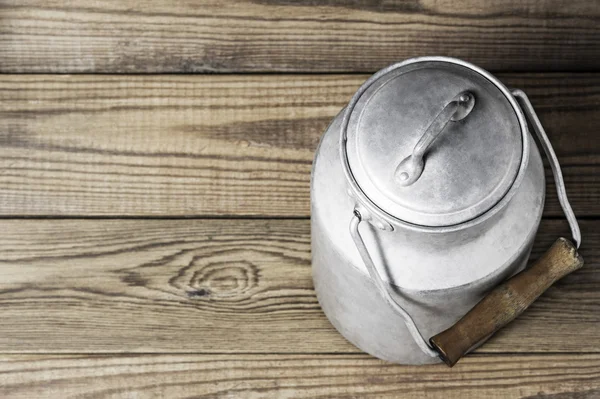 Yatay biçimde ahşap arka plan üzerinde eski süt olabilir alüminyum