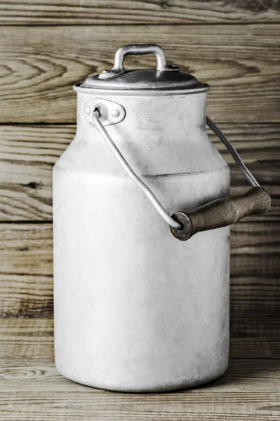 Dikey biçimde ahşap arka plan üzerinde eski süt olabilir alüminyum