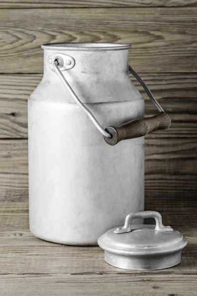 Dikey biçimde ahşap arka plan üzerinde eski süt olabilir alüminyum