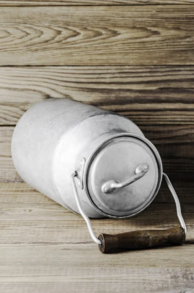 Aluminum old milk can on a wooden background in the vertical format — Stock Photo, Image