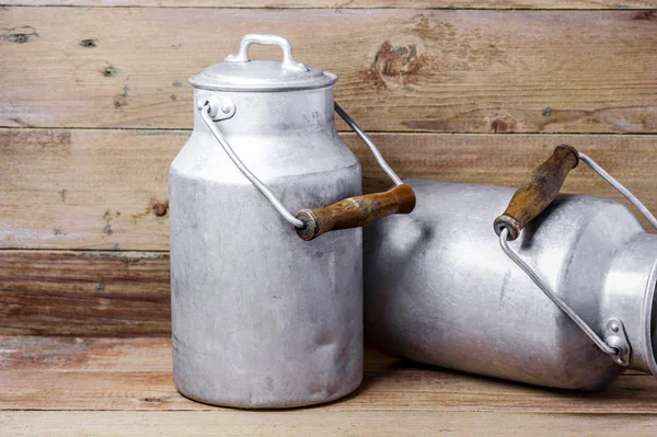 Yatay biçimde ahşap arka plan üzerinde eski süt kutuları alüminyum