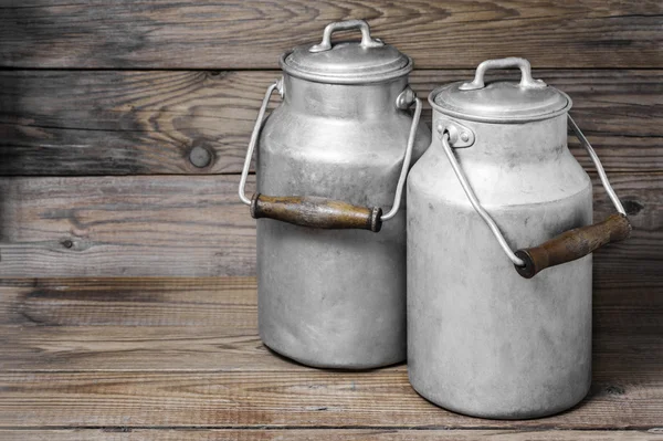 Aluminum old milk cans on a wooden background in the horizontal format