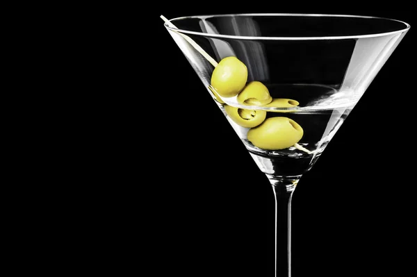 Nahaufnahme von trockenen Martini mit grünen Oliven auf schwarzem Hintergrund — Stockfoto