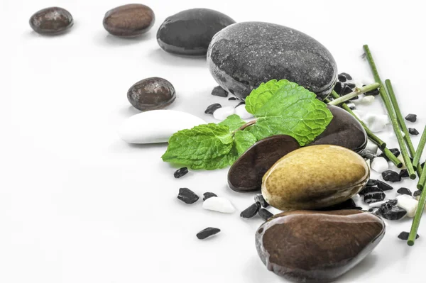 Zen stones with leaves of mint and sticks on white background — Stock Photo, Image