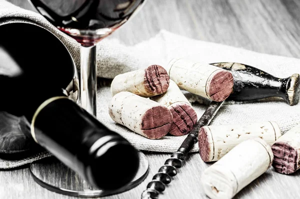 Corks, corkscrew, wine glass and bottle on a wooden background — Stock Photo, Image