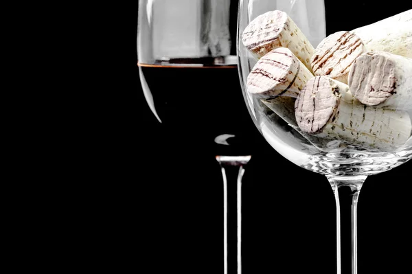 Wine corks and wine glass on a black background — Stock Photo, Image