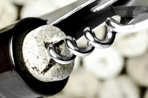 Tirbuşon bir şişe şarap mantarlar arka plan üzerinde açma