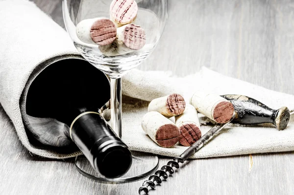 Sughero, cavatappi, bicchiere da vino e bottiglia su fondo di legno — Foto Stock
