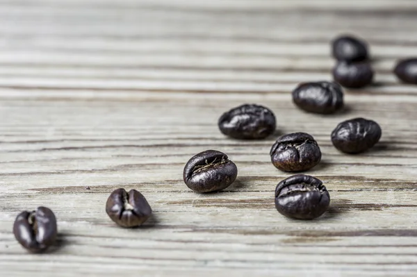 Close-up de grãos de café em um fundo de madeira Fotografias De Stock Royalty-Free