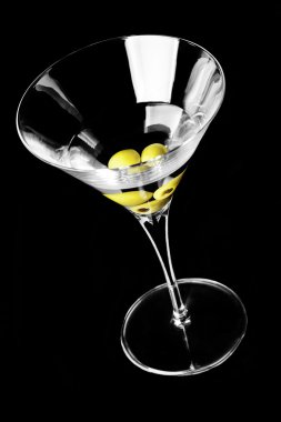 Siyah bir arka plan üzerinde zeytinli martini cam